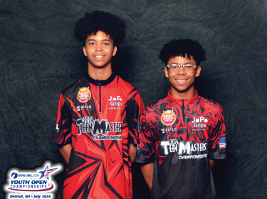 students wearing black and read jerseys against a gray backdrop